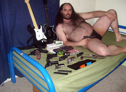 fat_hairy_guy_on_bed_with_guns.jpeg